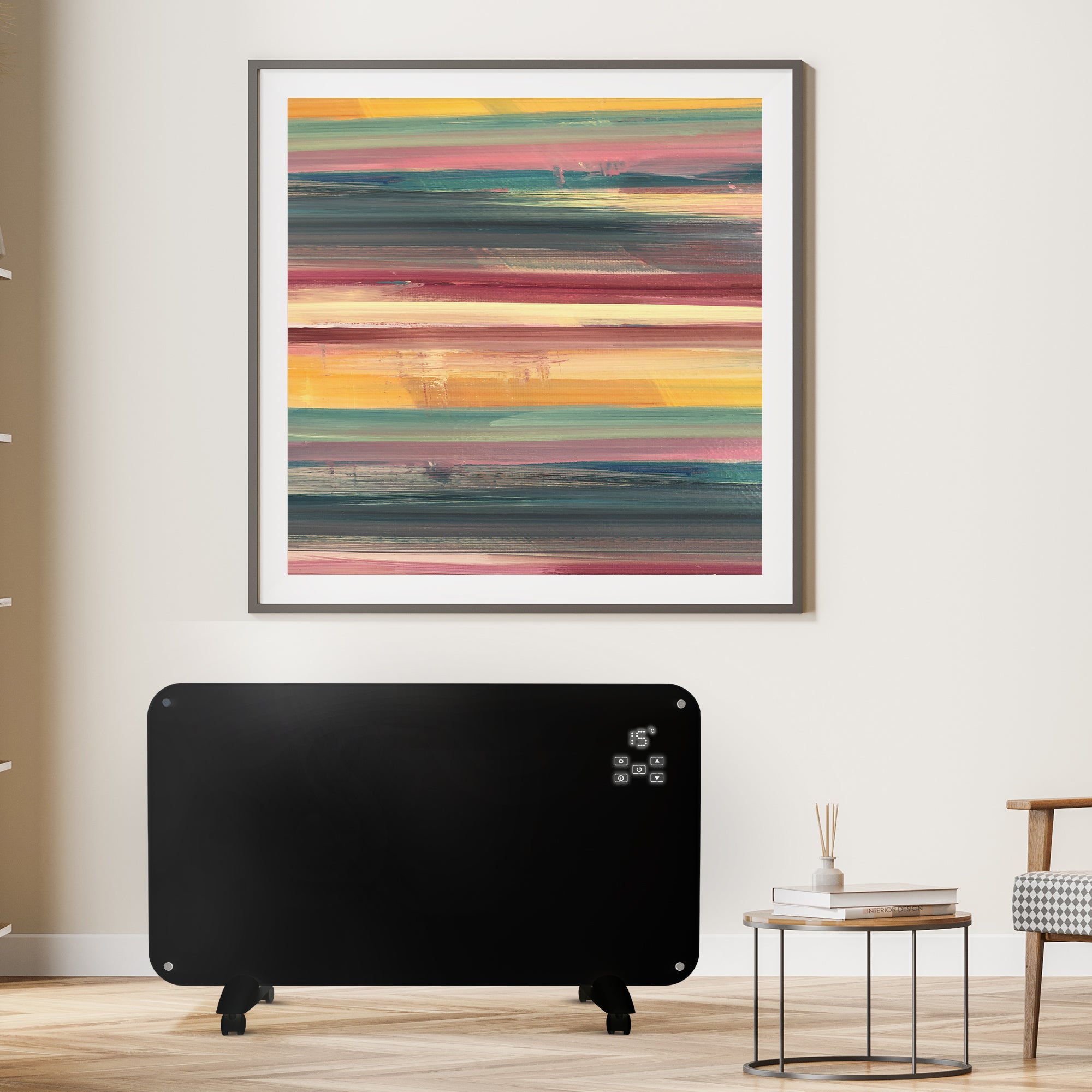 Lifestyle photograph of the black Designer Electric Glass Panel Heater 2000W With Smart WIFI Alexa and Remote Control in a white background with an abstract multi coloured painting on the wall