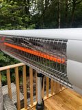 Load image into Gallery viewer, Lifestyle close up of the KMH-3000R 3KW Free Standing Infrared Heater&#39;s heating element with a wooden patio deck and greenery in the background
