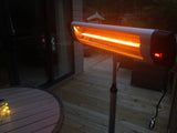 Load image into Gallery viewer, Close-up of the KMH-2500R 2.5KW Free Standing Infrared Heater on a wooden patio at night