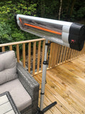 Load image into Gallery viewer, Angled overhead shot of the KMH-3000R 3KW Free Standing Infrared Heater on a wooden patio next to a grey wicker sofa bench