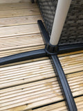 Load image into Gallery viewer, Close up of the KMH-3000R 3KW Free Standing Infrared Heater&#39;s black stand on a wooden patio stand next to a grey wicker sofa bench