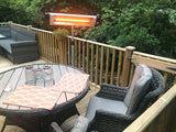 Load image into Gallery viewer, KMH-3000R 3KW Free Standing Infrared Heater on a wooden patio next to grey wicker chairs and wicker grey table