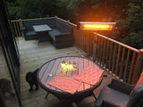 Load image into Gallery viewer, KMH-3000R 3KW Free Standing Infrared Heater on a wooden patio next to grey wicker furniture at night