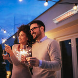 Load image into Gallery viewer, A couple enjoy a night outside in their garden with sparklers and glasses of champagne, with the Silver KMH-20R 2KW Wall Mounted Infrared Outdoor Heater mounted on their house in the background